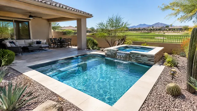 Compact, low-maintenance backyard at a single-story home in a southeast Mesa, Arizona golf community: a small remodeled plunge pool and spa with smooth light coping, gravel desert landscaping and a covered patio