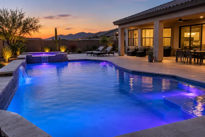 Residential pool at dusk lit by new color LED underwater lights glowing soft blue and violet